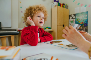 a young toddler with nonverbal autism works with a specialist to learn communication techniques
