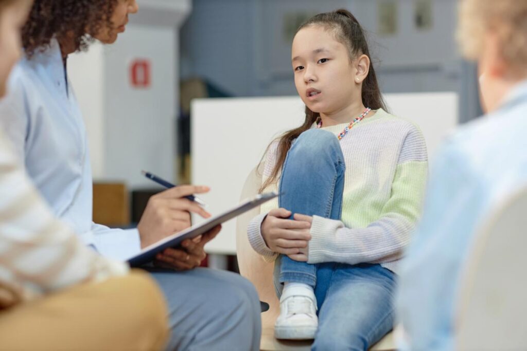 young girl sits on a couch while talking with her specialist about the importance of involvement of parent and aba services