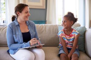 a specialist sits with a young child and works on the 7 dimensions of aba